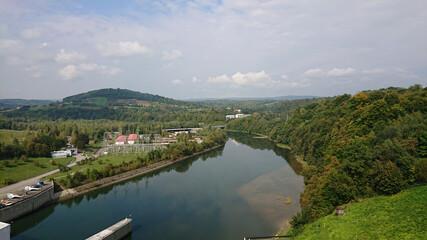 Fototapeta na wymiar Looking at the wide river flowing between the hills