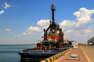 A large blue tug, a ship in sea, river port, moored near the pier. Tugboat stands in the seaport, Odessa, Ukraine.