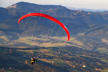 Paragliding in the sunset above a idyllic landscape