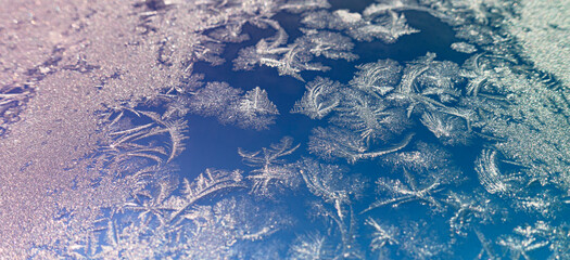 Frozen surface with icy pattern on window glass in cold winter day
