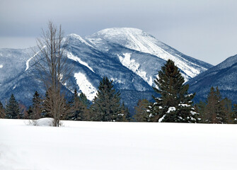 Snowy winter landscape with snow covered mountains and 46er High Peaks popular for hiking and climbing, Adirondacks New York - 411603590