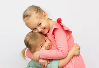 Fotobehang Two sisters hug each other , studio shot © Irina