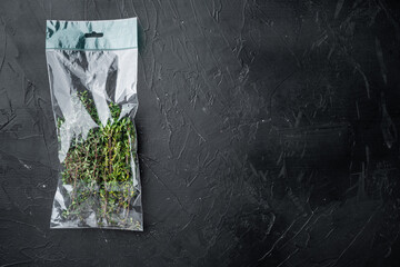 Thyme in plastic bag, on black background, top view flat lay  , with copyspace  and space for text
