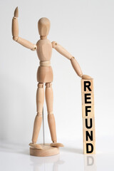 The wooden man raised his hand, and under his left hand he has cubes with the inscription - REFUND