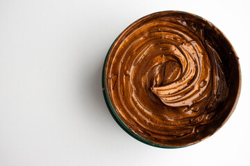 jar of cosmetic cream of copper color on a white background
