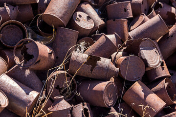 Close up of rusty pile of old food and oil cans from a mining claim in the desert