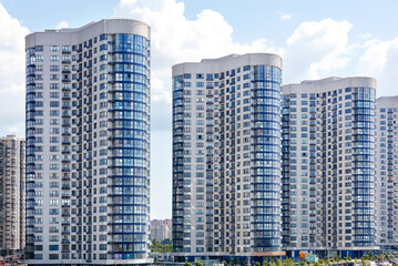 Fototapeta premium Tall houses of white-blue high-rise buildings in a new district of the city.