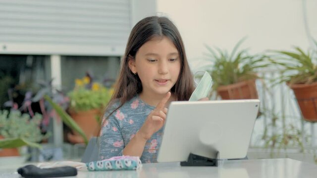 Ni&ntilde;a ense&ntilde;ando a su familia por internet varios modelos y colores de m&aacute;scaras  covid-19