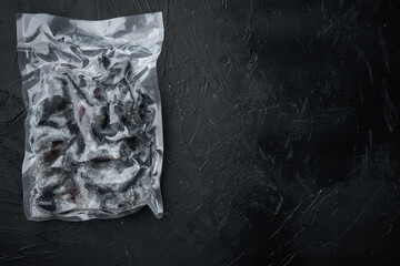 Frozen Mussels in vacuum pack, on black background, top view flat lay  , with copyspace  and space for text