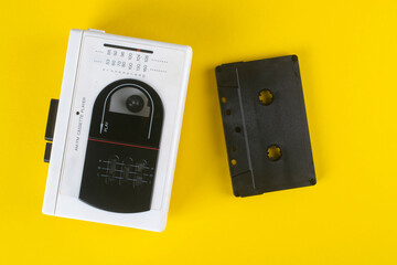 Vintage cassette player and audio cassette on a yellow background