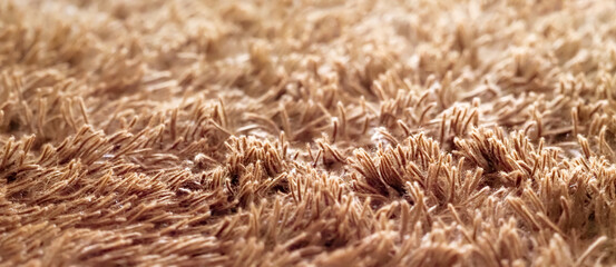 Soft fluffy cozy blanket, brown bedspread, panoramic view. Shaggy texture. Beige fur blanket, high pile fabric texture