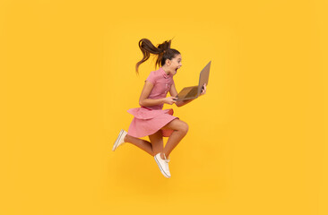 surprised kid girl shopper jumping with laptop go online shopping, hurry up