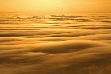 Sunset above the clouds and fog, seen from a mountain