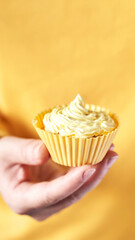Yellow monochrome bakery. Sustainable cupcake cup. Hold in hand. Gold maffin cream. Trendy colourful desert. Bright birthday gift. Vertical banner for story. Copyspace