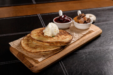 pancakes with sour cream and filling on a wooden board 