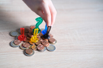 pile of metal euro cent coins lies on the table in bulk, plastic question and exclamation marks,...