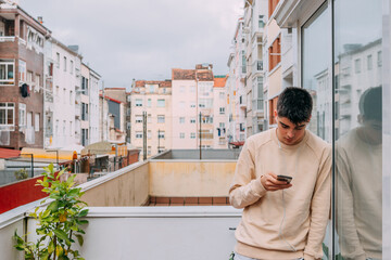 young man with phone and headphones in the city