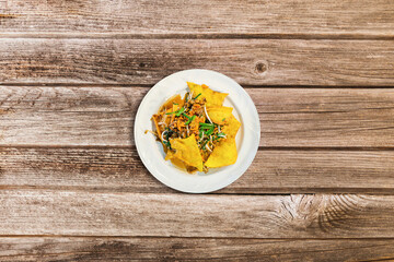 Pad Thai- traditional Thai dish. stir fried rice noodles with shrimps and vegetables on wooden background