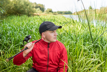 Young fisherman in reeds with spinning. Outdoor recreation.