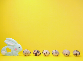 Frame for text with Easter bunny and quail eggs. Side view on a yellow background. Easter. Copyspace.