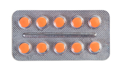 Orange pills in metallic blister. Isolated on white background.
