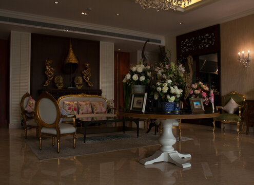 Elegant hotel lobby with chic furniture, ornate golden decor and rose flowers bouquets