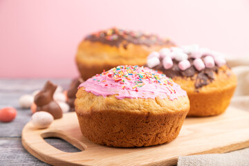 Homemade glazed and decorated easter pies on a gray wooden background and linen textile. Side view, selective focus, close up.