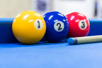 Bolas y taco de billar sobre mesa de color azul