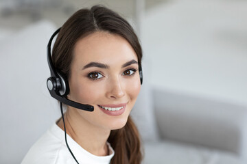 Beautiful smiling woman consultant in headphones with a microphone.