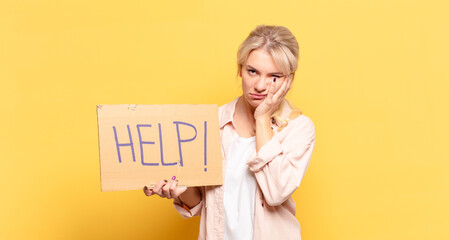 blonde woman feeling bored, frustrated and sleepy after a tiresome, dull and tedious task, holding...