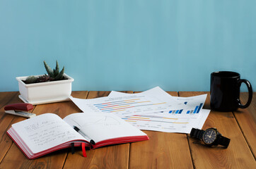 Fototapeta premium notebook and charts are on the wooden office table