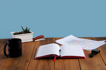 notebook and charts are on the wooden office table