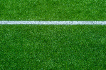 Green synthetic grass sports field with white line shot from above. Soccer, rugby, football,...
