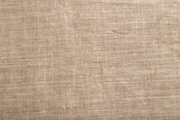 Fototapeta na wymiar Fragment of rough linen tissue. Top view, natural textile background.