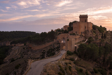 Fototapeta na wymiar Landscape with the fortified city of Alarcon with its watchtowers and the castle on top of the hill in a colorful sunset, Cuenca, Spain