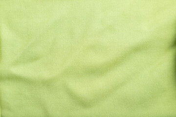 Fragment of smooth green linen tissue. Top view, natural textile background.