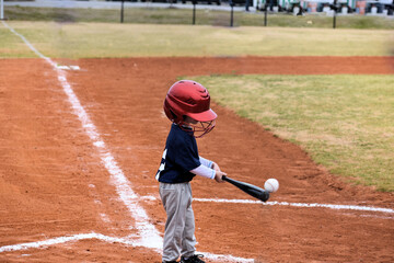 child playing baseball getting a hit 