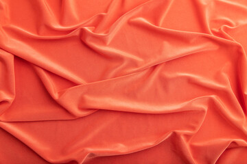 Fragment of red silk tissue. Top view, natural textile background.