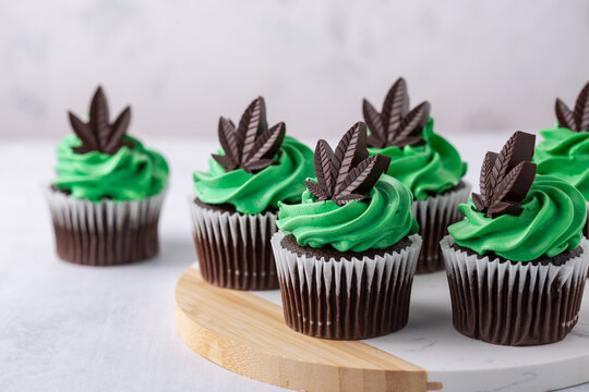 Delicious chocolate cannabis cupcakes infused with cannabis. Cannabis concept for a marijuana themed party. 