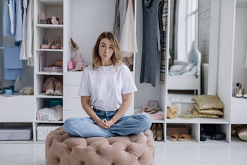 Portrait of a young woman. Woman in her modern dressing room looks at the camera