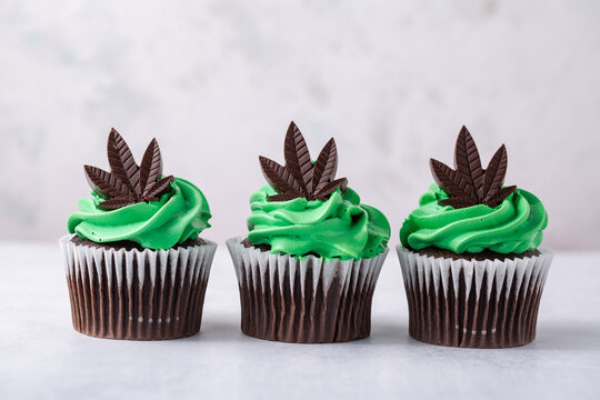 Delicious chocolate cannabis cupcakes infused with cannabis. Cannabis concept for a marijuana themed party. 