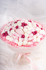 Beautiful bouquet consisting of marshmallows and raspberries a on a marble background. Copy space for a text.