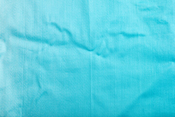 Fragment of smooth cotton blue tissue. Top view, natural textile background.