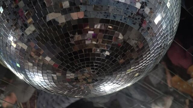 Disco ball with bright rays, night party with dark background. Party dance hall celebration at night club with lots of flashy colors. Rotating disco mirror ball. 