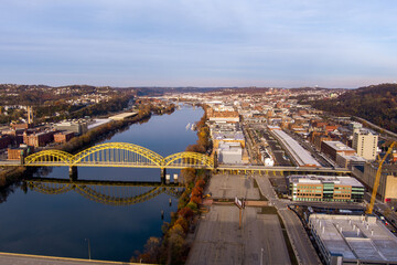 Aerial view of Pittsburgh, Pennsylvania's Strip District (right). The David McCullough 16th Street Bridge crosses the Allegheny River from Troy Hill (left). - obrazy, fototapety, plakaty