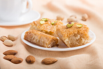 traditional arabic sweets and a cup of coffee on a gray concrete background. side view, selective focus, macro.