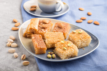 traditional arabic sweets and a cup of coffee on a gray concrete background. side view, selective focus.