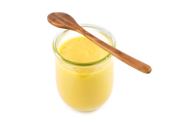 Homemade ghee in jar and wooden spoon .   Ghee is purified butter.    isolated on white background. 