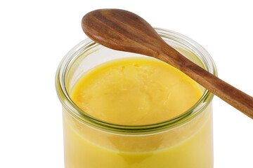 Homemade ghee in jar and wooden spoon .   Ghee is purified butter.    isolated on white background. 