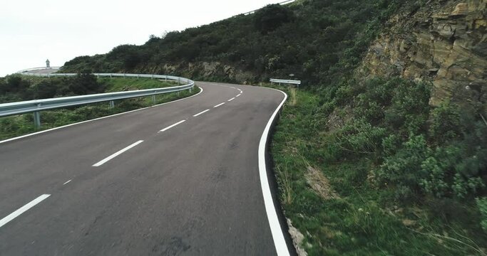 Empty long mountain road to the horizon on a sunny summer day at bright sunset - aerial drone shot